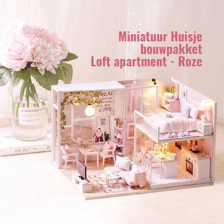 Romantisch miniatuur poppenhuis loftstijl met roze accenten en decoratieve bloem, gepresenteerd op een witte achtergrond.